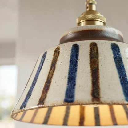 Textured Ceramic Pendant Light with Brass Details and Warm Lighting